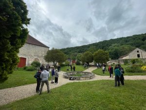 Participants en atelier collectif dans la cour d'un bâtiment historique en plein air, accompagnement RH en nature avec Les RH O'naturel
